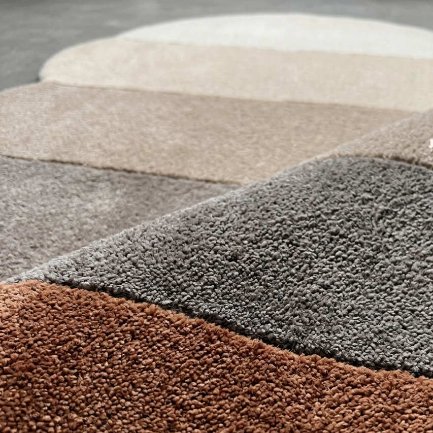 Close-up of textured brown, gray, and beige carpet samples.